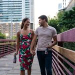 man and woman standing on wooden bridge during daytime