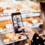 woman taking photo food display