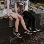 two person sits on fence