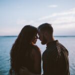 man and woman planning to kiss other near ocean