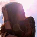 woman in black top holding her hair looking up