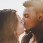 man kissing woman during daytime