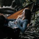 man and woman lying on hammock