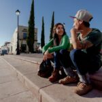 man and woman sitting on concrete bench during daytime