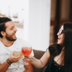 man in black tank top holding wine glass