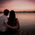 man and woman sitting on dock