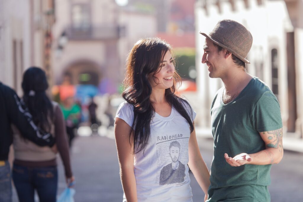 woman in gray crew neck t-shirt and gray fedora hat standing beside woman in gray