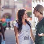 woman in gray crew neck t-shirt and gray fedora hat standing beside woman in gray