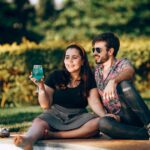 man and woman sitting on brown wooden bench during daytime