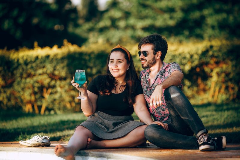 man and woman sitting on brown wooden bench during daytime