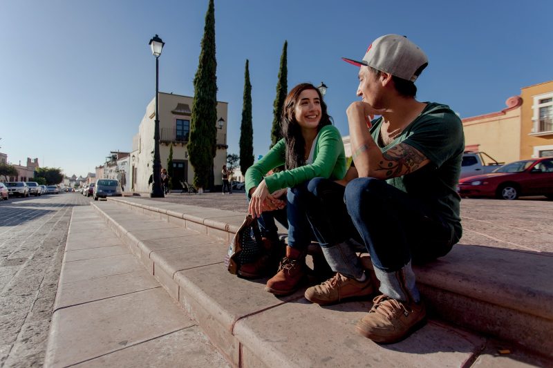 man and woman sitting on concrete bench during daytime